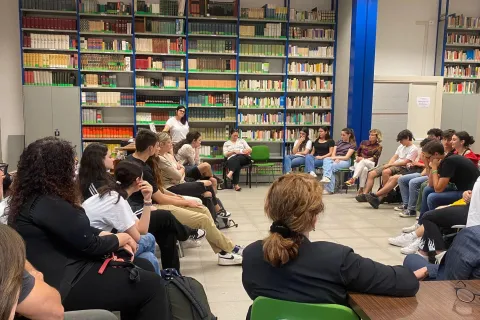 Persone in biblioteca che assistono all'evento